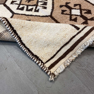 Folded edge of Ankara Vintage Wool Runner on a gray floor - H+E Goods Company