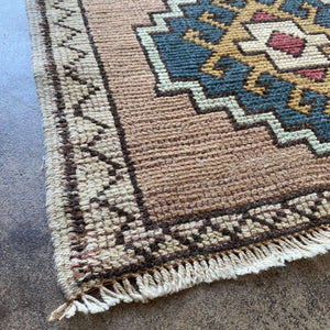 Close-up view of the edge of Deixa Vintage Wool Rug on earth colored floor - H+E Goods Company