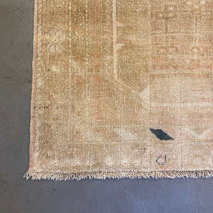 Edge of Derya Vintage Oushak Rug on gray floor - H+E Goods Company