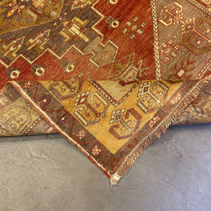 Folded edge of Nuria Vintage Turkish Rug on gray floor - H+E Goods Company