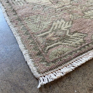 Close-up view of Pelin Distressed Vintage Rug on earth colored floor - H+E Goods Company